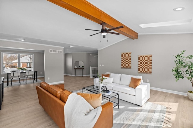 living room with ceiling fan, light hardwood / wood-style floors, and lofted ceiling with skylight