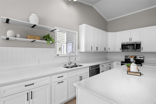 kitchen with white cabinets, stainless steel appliances, lofted ceiling, and sink