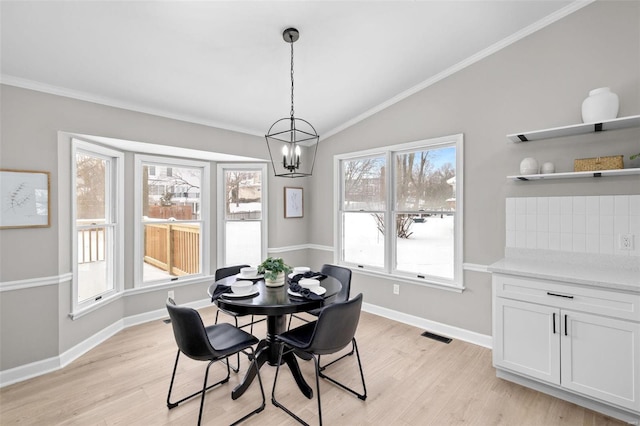 dining room featuring light wood-type flooring, an inviting chandelier, vaulted ceiling, and a healthy amount of sunlight