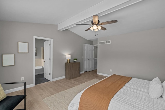 bedroom featuring ensuite bath, ceiling fan, light hardwood / wood-style floors, and vaulted ceiling with beams