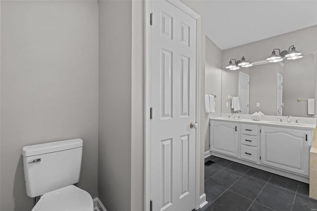 bathroom with tile patterned flooring, vanity, and toilet