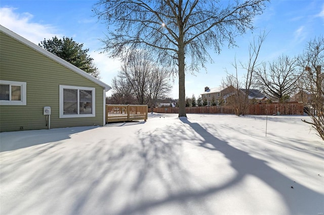 snowy yard featuring a wooden deck