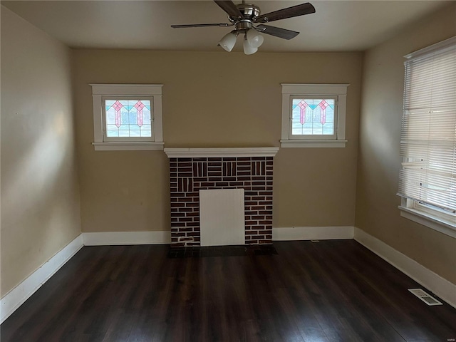 unfurnished living room featuring ceiling fan, a healthy amount of sunlight, and dark hardwood / wood-style floors