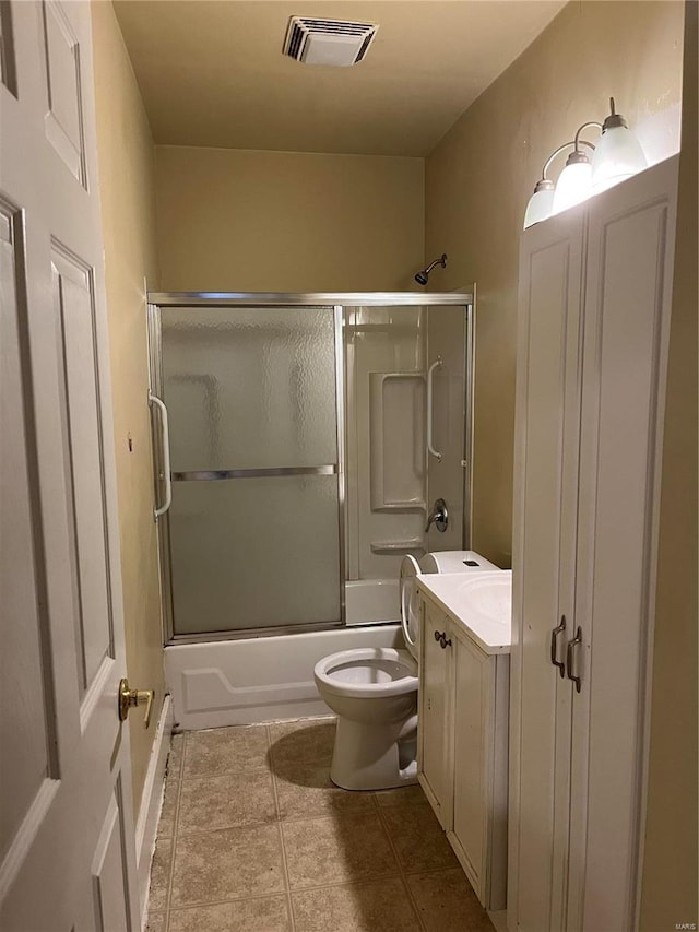 full bathroom featuring tile patterned floors, vanity, toilet, and bath / shower combo with glass door