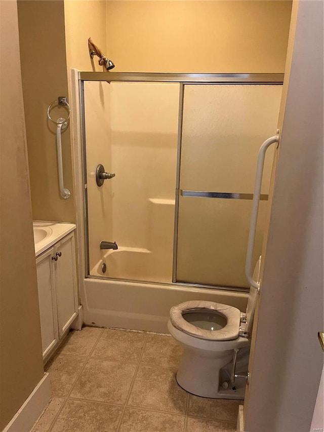 full bathroom with tile patterned floors, vanity, toilet, and bath / shower combo with glass door