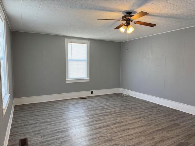 empty room with dark hardwood / wood-style flooring and ceiling fan