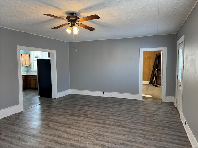 spare room with dark hardwood / wood-style flooring, ceiling fan, and a healthy amount of sunlight