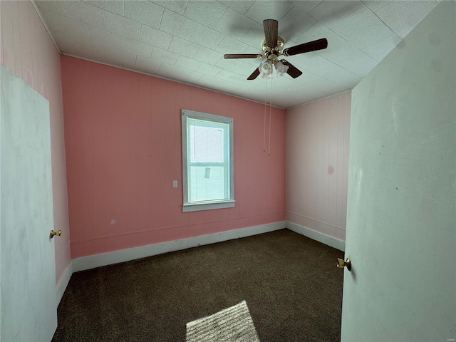 unfurnished room featuring dark carpet and ceiling fan