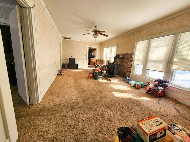 interior space with ceiling fan and a wood stove