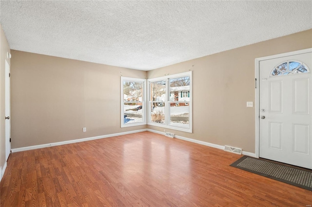 entrance foyer featuring wood-type flooring and a textured ceiling