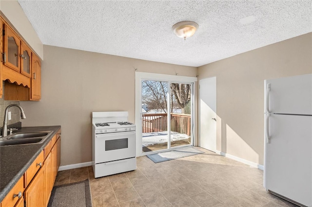 kitchen featuring white appliances, sink, and a textured ceiling