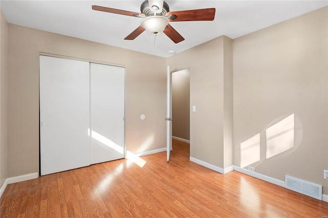 unfurnished bedroom featuring a closet, ceiling fan, and light wood-type flooring