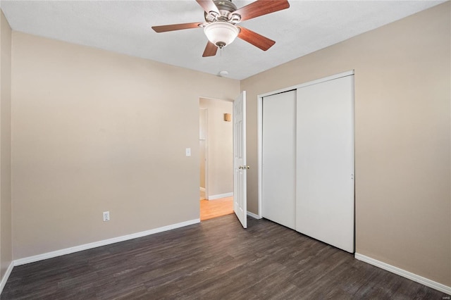 unfurnished bedroom featuring dark wood-type flooring, ceiling fan, and a closet