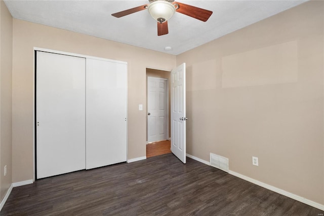 unfurnished bedroom featuring dark hardwood / wood-style flooring, a closet, and ceiling fan