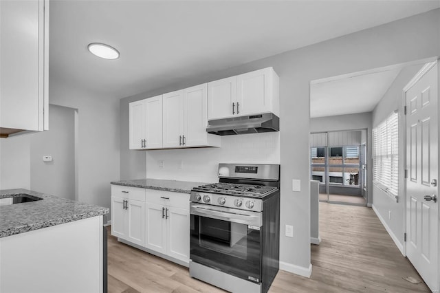 kitchen featuring white cabinets, stone countertops, stainless steel range with gas cooktop, and light hardwood / wood-style flooring