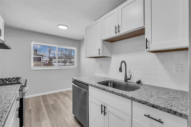 kitchen featuring white cabinetry, sink, light stone counters, and appliances with stainless steel finishes