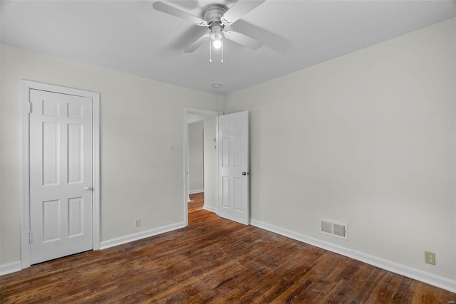 unfurnished room featuring ceiling fan and dark wood-type flooring