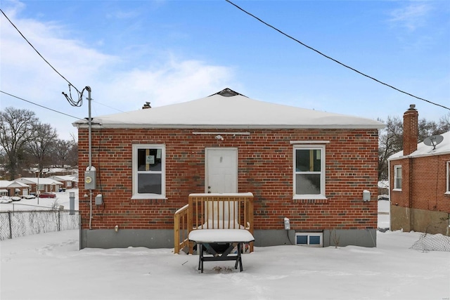 view of snow covered back of property