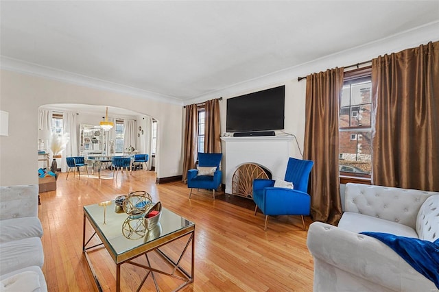 living room featuring hardwood / wood-style flooring, a notable chandelier, and ornamental molding