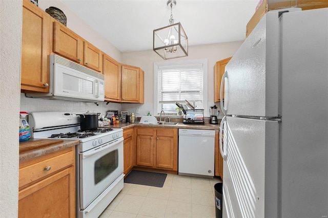 kitchen featuring pendant lighting, white appliances, sink, decorative backsplash, and a notable chandelier