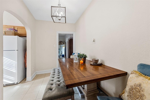 tiled dining space featuring an inviting chandelier