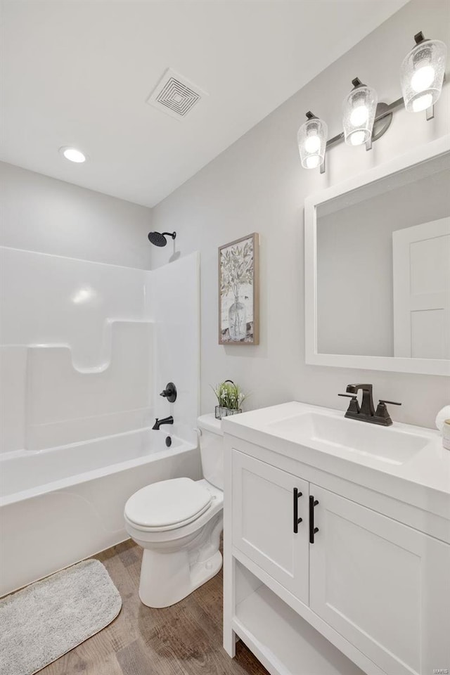 full bathroom featuring hardwood / wood-style flooring, vanity, toilet, and tub / shower combination