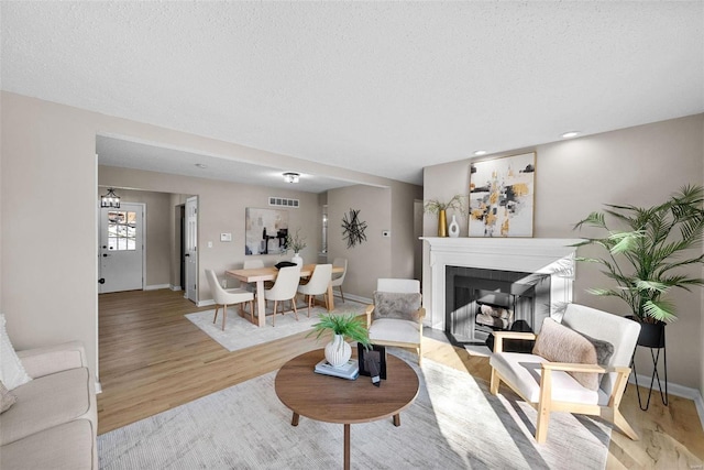 living room featuring a textured ceiling and light wood-type flooring