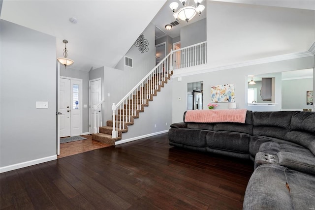 living room with a high ceiling, an inviting chandelier, a wealth of natural light, and hardwood / wood-style floors