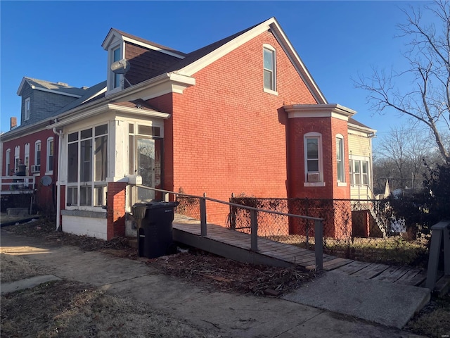 view of side of property with a wooden deck and a sunroom