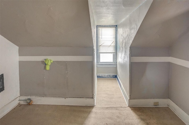 bonus room with a textured ceiling and light carpet