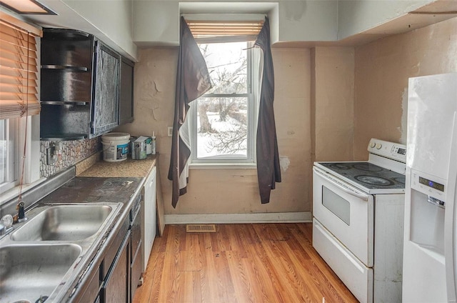 kitchen featuring light hardwood / wood-style floors, white appliances, and sink