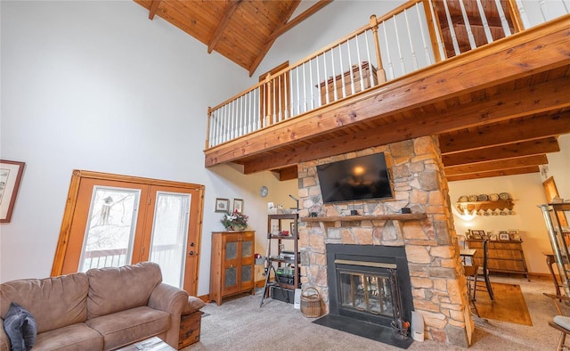 living room featuring light carpet, a towering ceiling, wood ceiling, beamed ceiling, and a stone fireplace