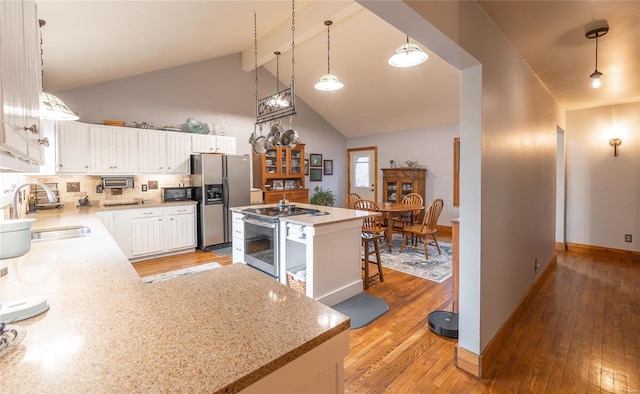 kitchen with white cabinets, backsplash, sink, and stainless steel appliances