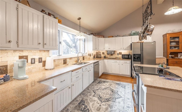 kitchen featuring appliances with stainless steel finishes, backsplash, sink, pendant lighting, and white cabinets