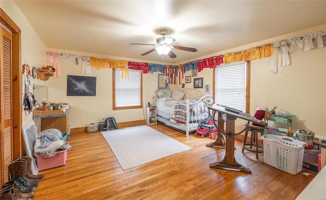 bedroom with multiple windows, ceiling fan, and wood-type flooring