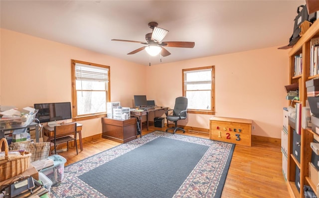 office area with light hardwood / wood-style flooring, a wealth of natural light, and ceiling fan