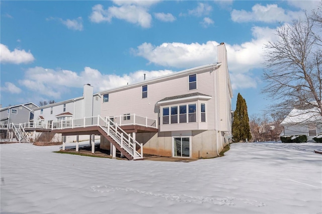 snow covered rear of property featuring a wooden deck