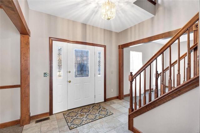 tiled foyer with a notable chandelier