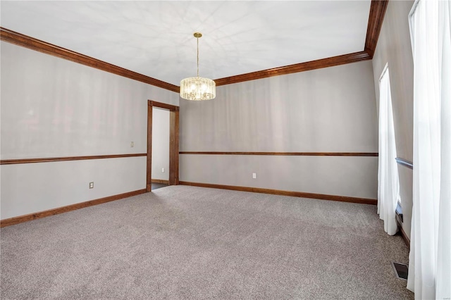 empty room with ornamental molding, an inviting chandelier, and carpet flooring