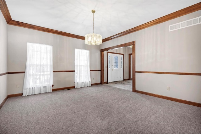 carpeted empty room with a notable chandelier and crown molding