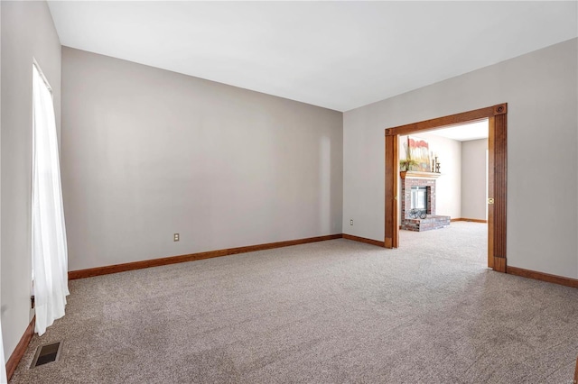 carpeted empty room featuring a fireplace