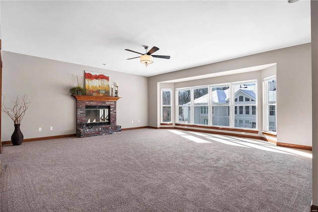 unfurnished living room with a brick fireplace, ceiling fan, and carpet