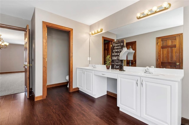 bathroom featuring toilet, vanity, an inviting chandelier, and hardwood / wood-style flooring