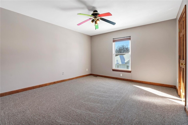 carpeted spare room with ceiling fan