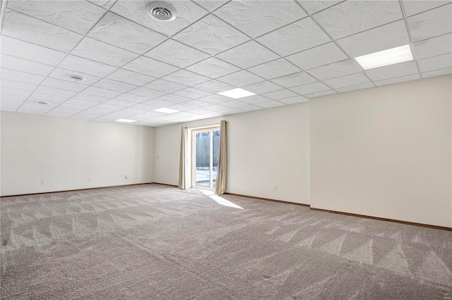 empty room with a drop ceiling and light carpet