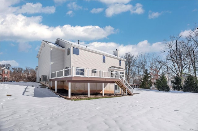 snow covered rear of property featuring a wooden deck