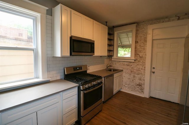 kitchen featuring sink, dark hardwood / wood-style floors, tasteful backsplash, white cabinetry, and stainless steel appliances