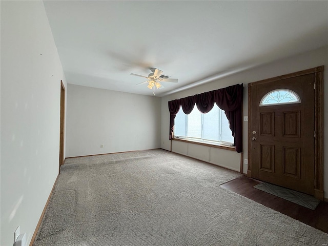 foyer featuring ceiling fan and carpet floors