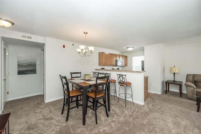 carpeted dining area featuring a notable chandelier