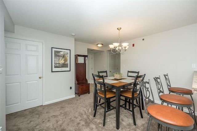 carpeted dining area featuring a chandelier